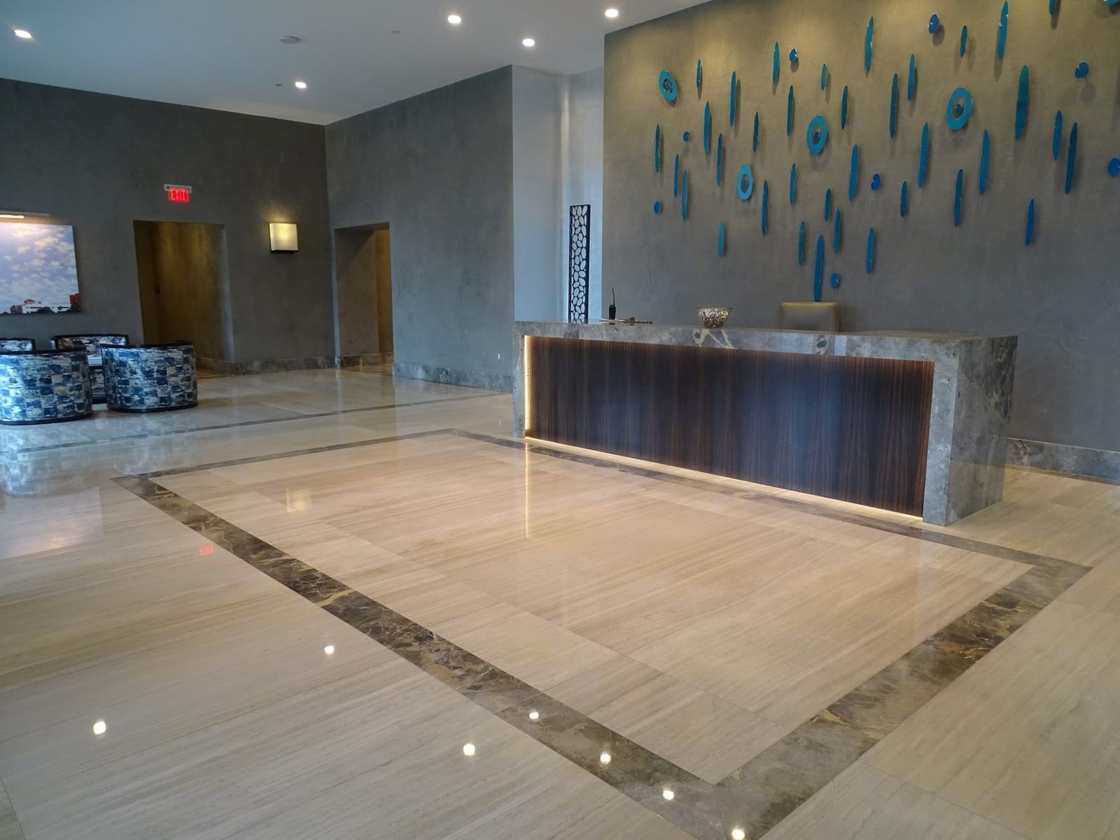 Mitered stone reception desk in an office building lobby by Cangelosi Company