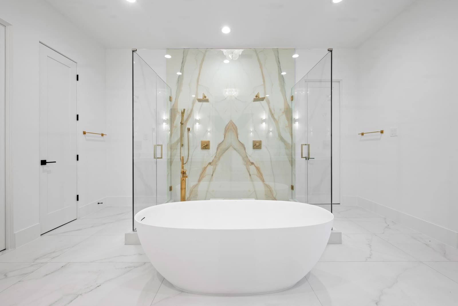 Freestanding tub and book-matched marble bathroom fabricated by Cangelosi Company