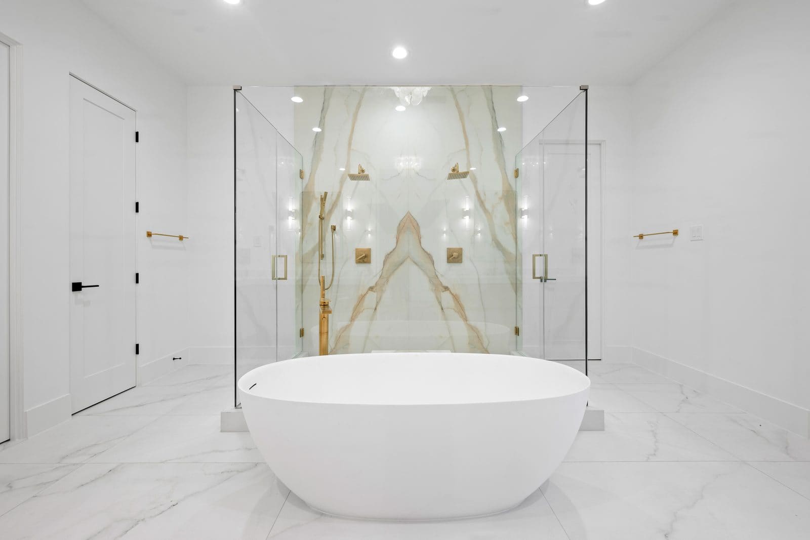 Bookmatched marble shower surround and freestanding tub by Cangelosi Company
