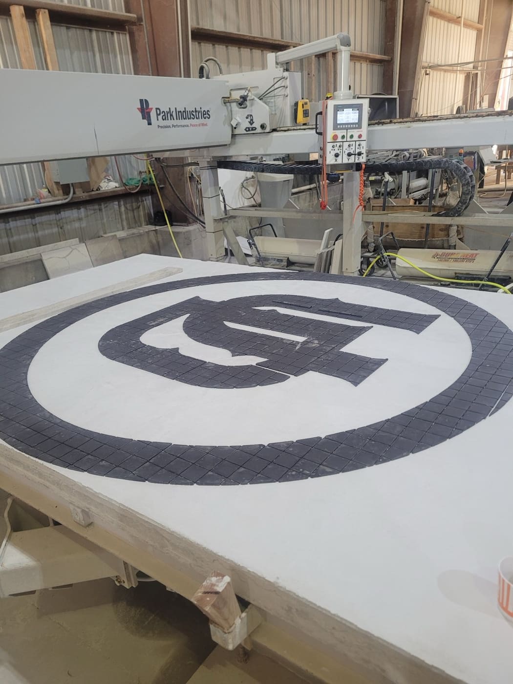 5-axis CNC waterjet cutting a stone medallion at Cangelosi Company